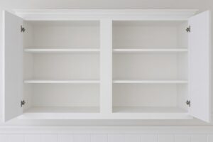 Empty white wall cabinet with open shelves for showcasing items, sleek melamine finish in kitchen setting